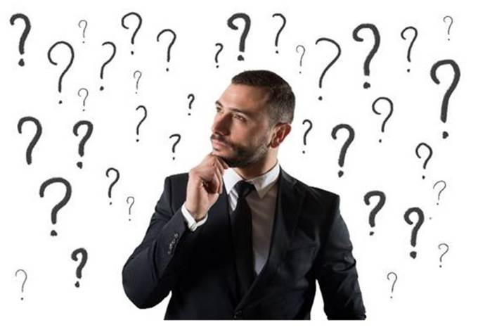 Una imagen de un varón adulto joven vestido de traje y corbata, de semblante muy pensativo y con muchos signos de pregunta alrededor de su persona.