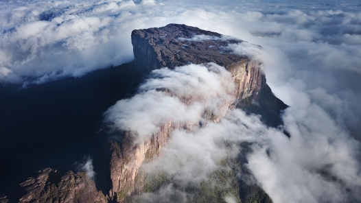 Este masivo promontorio de roca maciza que se yergue entre neblinas y nubes ilustra el tema Sobre esta roca edificaré mi iglesia, documento en editoriallapaz que enfoca la iglesia de Cristo tal cual presentada por Jesucristo y sus apóstoles en el Nuevo Testamento.