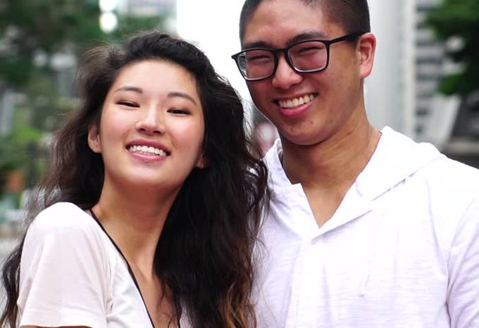 Un retrato de una pareja joven de la raza china, ambos sonriéndose.